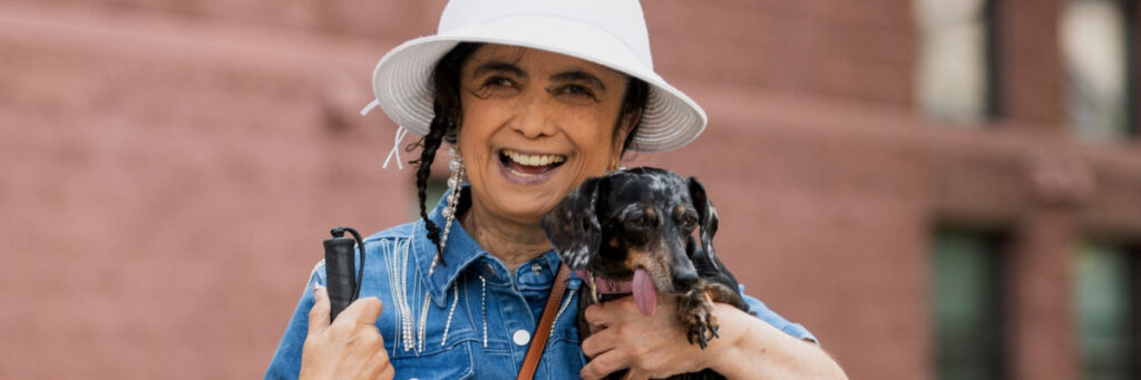 EOC participant, Trina, smiles while holding her dog Diamond