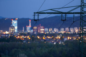power lines with lights of city in the background
